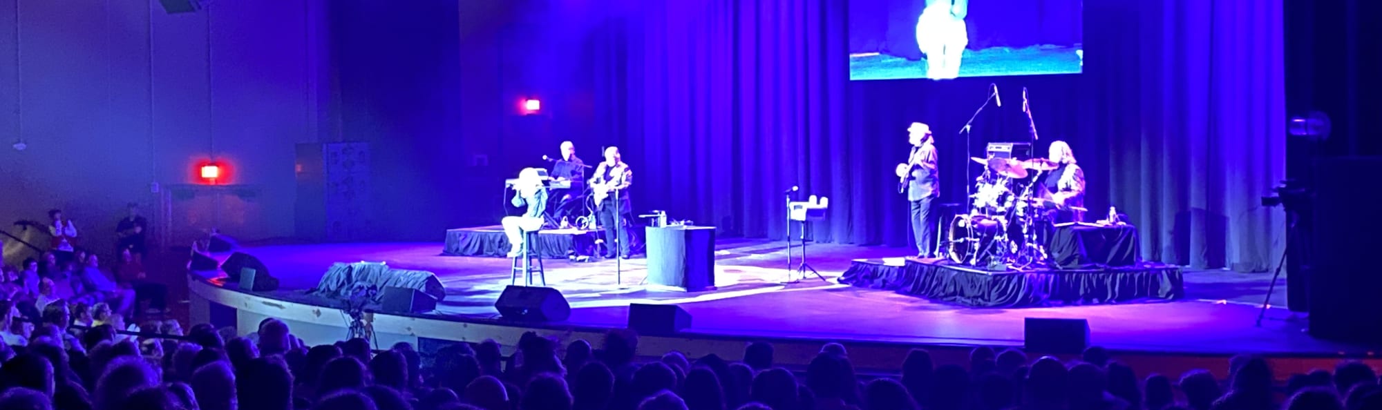 signer on stage in chair washed out by the lights Charleston